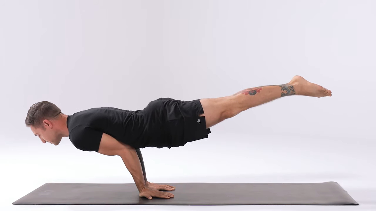 Person performing the Peacock Pose (Mayurasana), balancing their body horizontally on their hands with legs extended